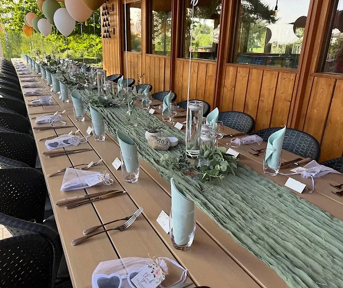 Grande tablée dressée sous la véranda en bois du restaurant Les Pâquis pour un mariage